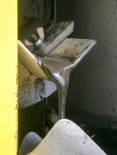 Continuous stream of recovered oil discharging from Monroe Belt Skimmer Monroe Oil Skimmer reclaiming condensed grease from venturi scrubber tank